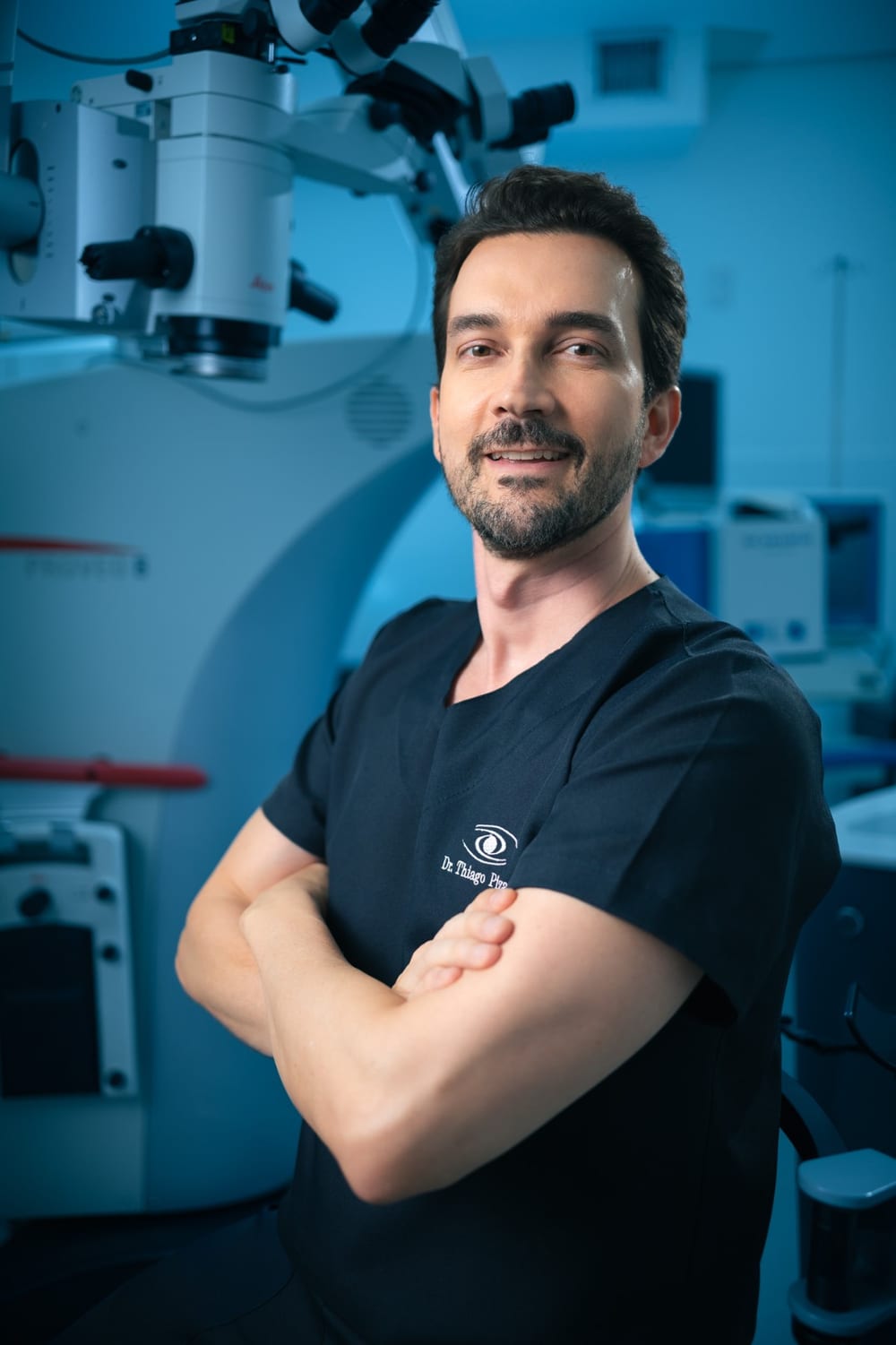 Dr. Thiago Pizarro, oftalmologista da ENNO, em frente ao microscópio cirúrgico da clínica